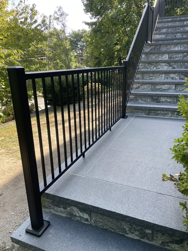 Black railing around an outdoor stone landing